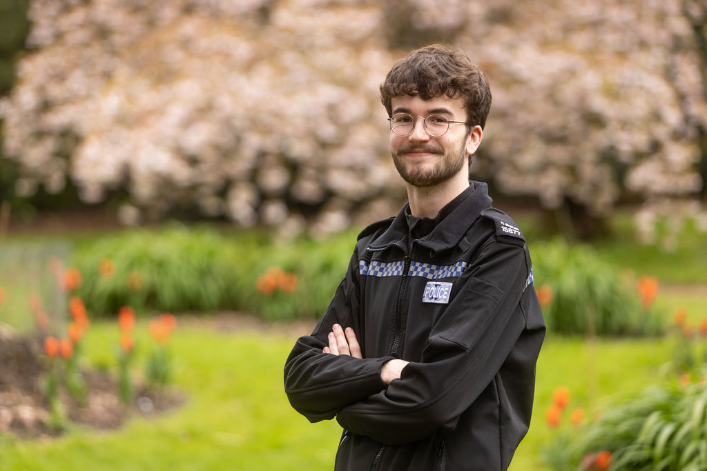 Former DCG Public Services students Harry Sherwin with his arms crossed, wearing his police uniform.