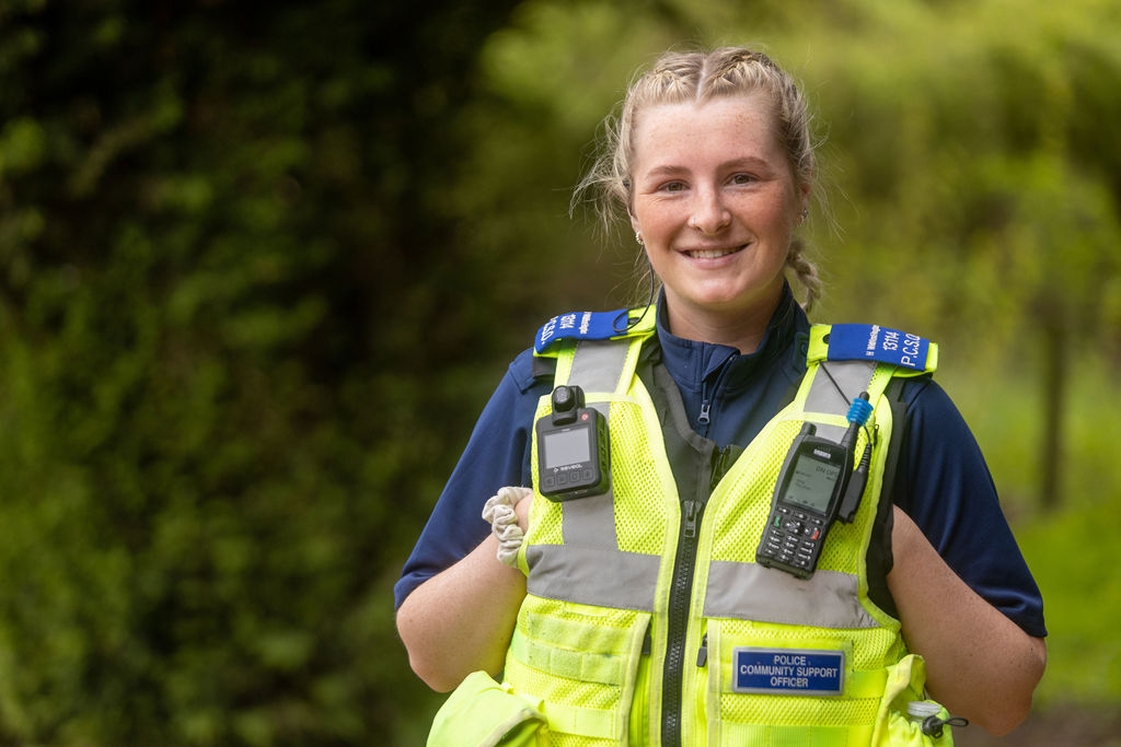 Former Derby College student Holly, a young lady with blonde hair wearing a hi-viz police gilet and uniform.