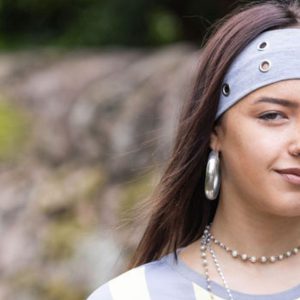 Art student Liana, a young student wearing a blue and white striped shirt and a blue bandana.